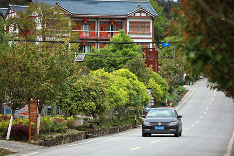 ◎ 一輛汽車經過花茂村(本月十三日攝)。(新華社記者劉續 攝)