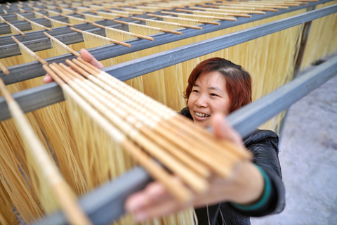 ◎ 本月十三日,一名花茂村村民在製作麵條。(新華社記者劉續 攝)