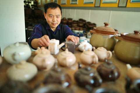 ◎ 本月十四日,在花茂村陶藝一條街,一位村民在整理陶藝作品。(新華社記者劉續 攝)