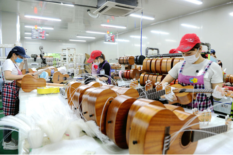 ◎ 工人給尤克里里上弦。(中新社記者張金川攝)