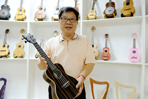 ◎ 陳永茂介紹尤克里里研發生產情況。(中新社記者張金川攝)