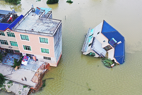 ◎ 七月十三日,江西鄱陽縣油墩街鎮荻溪村,一棟三層高的樓房被洪水侵襲整體傾斜倒下。受持續強降雨影響,鄱陽湖水位持續上漲,地處鄱陽湖水系西河之畔的鄱陽縣油墩街鎮,因洪水漫頂侵入,周邊數個村莊受淹。(中新社)