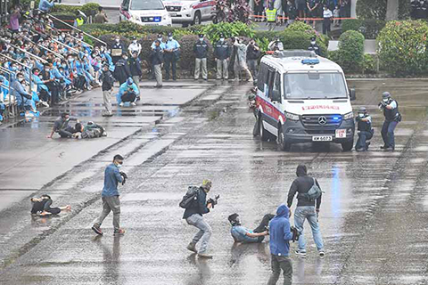 ◎ 四月十五日,香港國安法實施以來首個全民國家安全教育日,香港警察學院舉行了中式步操及反恐演習等多個表演項目。圖為警員在雨中進行反恐演習。(香港中通社)