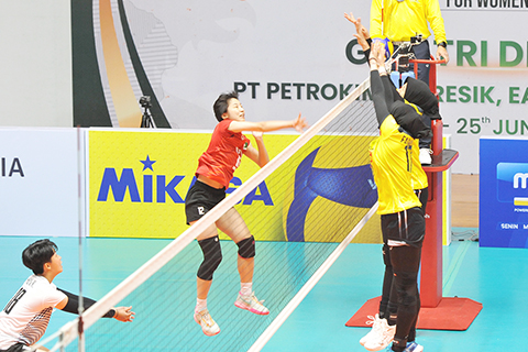 ◎ 澳門女排隊長周家敏(紅衣)網前搶分。