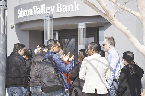 ◎ 二0二三年三月十三日,加州聖克拉拉市,矽谷銀行總部門前排隊等待辦理業務民眾的背影。(中新社記者劉關關 攝)