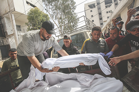 ◎ 據巴勒斯坦加沙地帶衞生部門五月十八日發佈的數據,以色列軍隊當天轟炸加沙地帶多地造成至少九十六人死亡、超過一百四十人受傷;自三月十八日以來,以色列方面對加沙地帶多地發動襲擊,已造成至少三千一百九十三人死亡、八千九百九十三人受傷。圖為當日,人們在加沙城一所醫院裡搬運遇難者遺體。(新華社發里澤克.阿卜杜勒賈瓦德 攝)