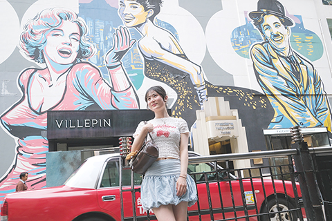 ◎ 五月二十日,香港特區政府「發展旅遊熱點工作組」公佈九個即將推出的旅遊熱點項目,希望給訪港旅客帶來新體驗。圖為一名女士在中環「打卡」。(中新社記者陳永諾 攝)