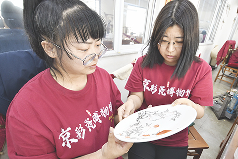 ◎ 北京三級工藝美術大師、京彩瓷第五代傳承人楊雪(右)在指導青年技師繪畫(六月十八日攝)。
