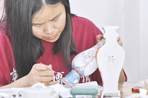 ◎ 京彩瓷傳承人王春艷進行釉上彩繪(六月十八日攝)。