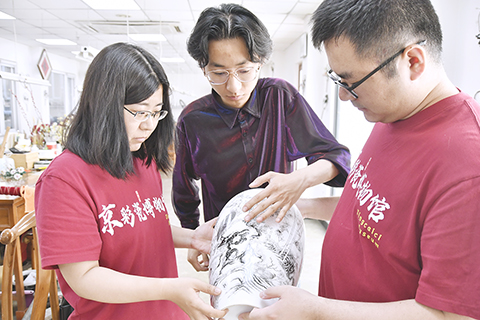 ◎ 北京三級工藝美術大師、京彩瓷第五代傳承人楊雪(左一)檢驗京彩瓷質量(六月十八日攝)。