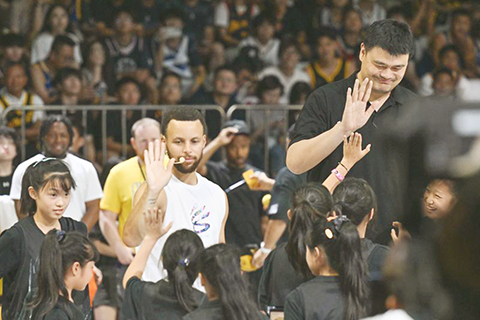 ◎ 八月二十日,姚明(右上)、居里(中上)與來自四川的鄉村女子籃球隊隊員互動。姚明亮相在重慶舉辦的「居里訓練營」活動,並觀看學員比賽。(新華社記者 陳誠 攝)