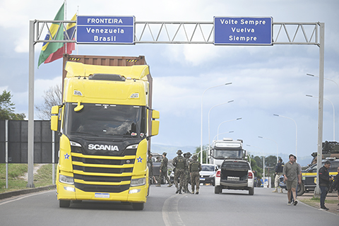 ◎ 帕卡賴馬是委內瑞拉移民陸路進入巴西的主要通道,巴西軍方近日在此處加強了對過境的巴西和委內瑞拉人員的檢查。目前,兩國邊境地區陸路口岸雙向開放,運行正常,暫未出現委內瑞拉難民激增的情況。圖為1月6日,在巴西北部羅賴馬州帕卡賴馬,一輛卡車穿過巴西和委內瑞拉的邊境。 (新華社發 盧西奧·塔沃拉攝)