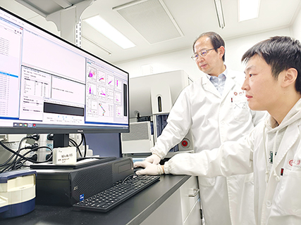 ◎ 北京大學未來技術學院副院長席建忠教授(左)與學生用流式細胞儀器檢測iVAC免疫激活程度。