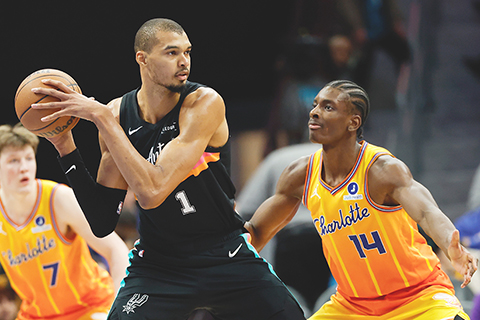 ◎ 一月三十一日,在北卡羅來納州夏洛特舉行的NBA常規比賽下半場,聖安東尼奧馬刺隊前鋒維克托.溫班亞馬(1)傳球,夏洛特黃蜂隊前鋒梅沙.迪亞巴特攔阻。(美聯社/內爾.雷德蒙德)