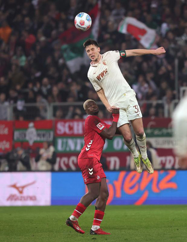 ◎ 二月二十七日,奧格斯堡隊球員舒洛達碧克(上)爭頂頭球。德國足球甲級聯賽第二十四輪比賽中,奧格斯堡隊主場二比0戰勝科隆隊。(新華社發)