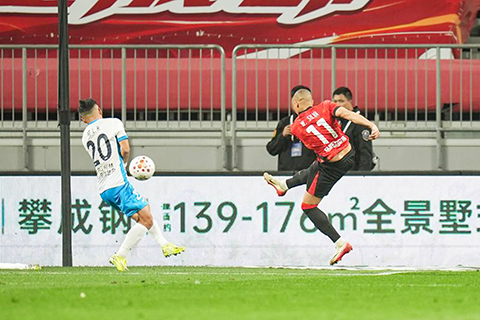 ◎ 四月三日,成都蓉城隊球員席爾瓦(右)射門得分。中國足球超級聯賽第四輪比賽中,成都蓉城隊主場五比一戰勝青島西海岸隊。(新華社記者 王曦 攝)