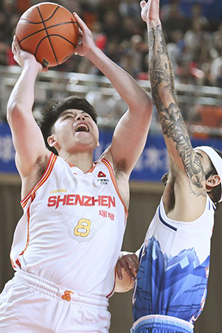 ◎ 四月六日,深圳馬可波羅隊容子峰(左)上籃。CBA常規賽第三十五輪比賽中,深圳馬可波羅隊客場一百零二比九十七戰勝新疆伊力特隊。 (新華社記者 胡虎虎 攝)